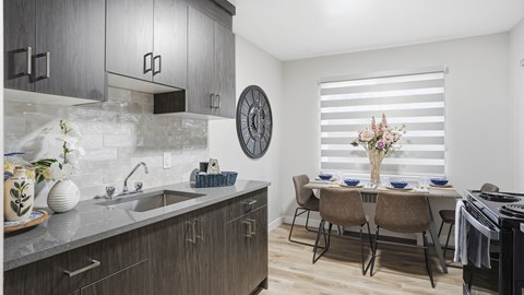 A modern kitchen with a dining table set for two.