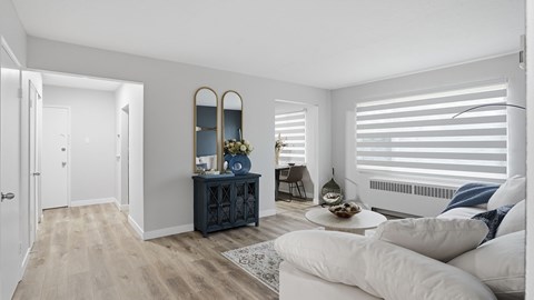 A living room with a white couch and a wooden cabinet.