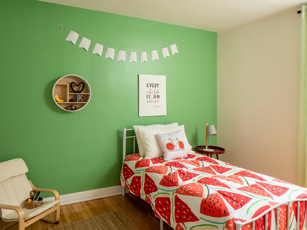 a bedroom with green walls and a bed with a red and white bedspread