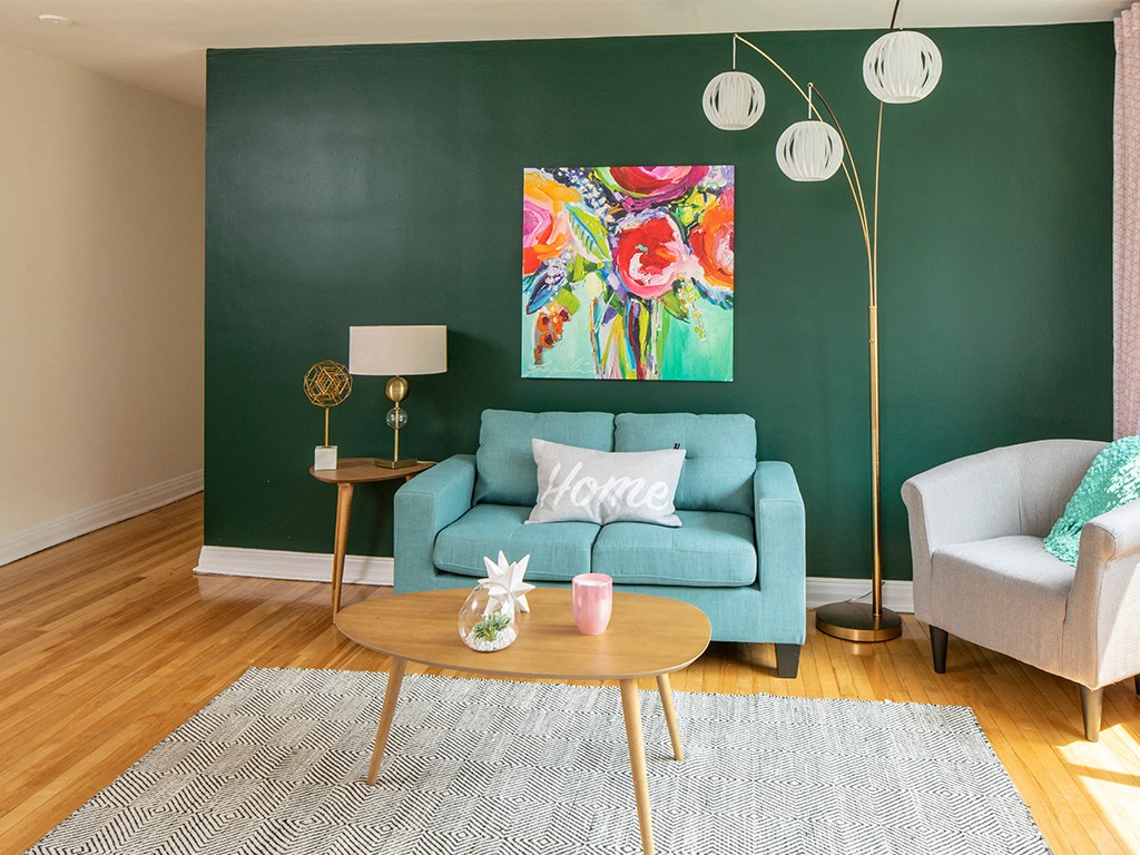 a living room with a green wall and a blue couch