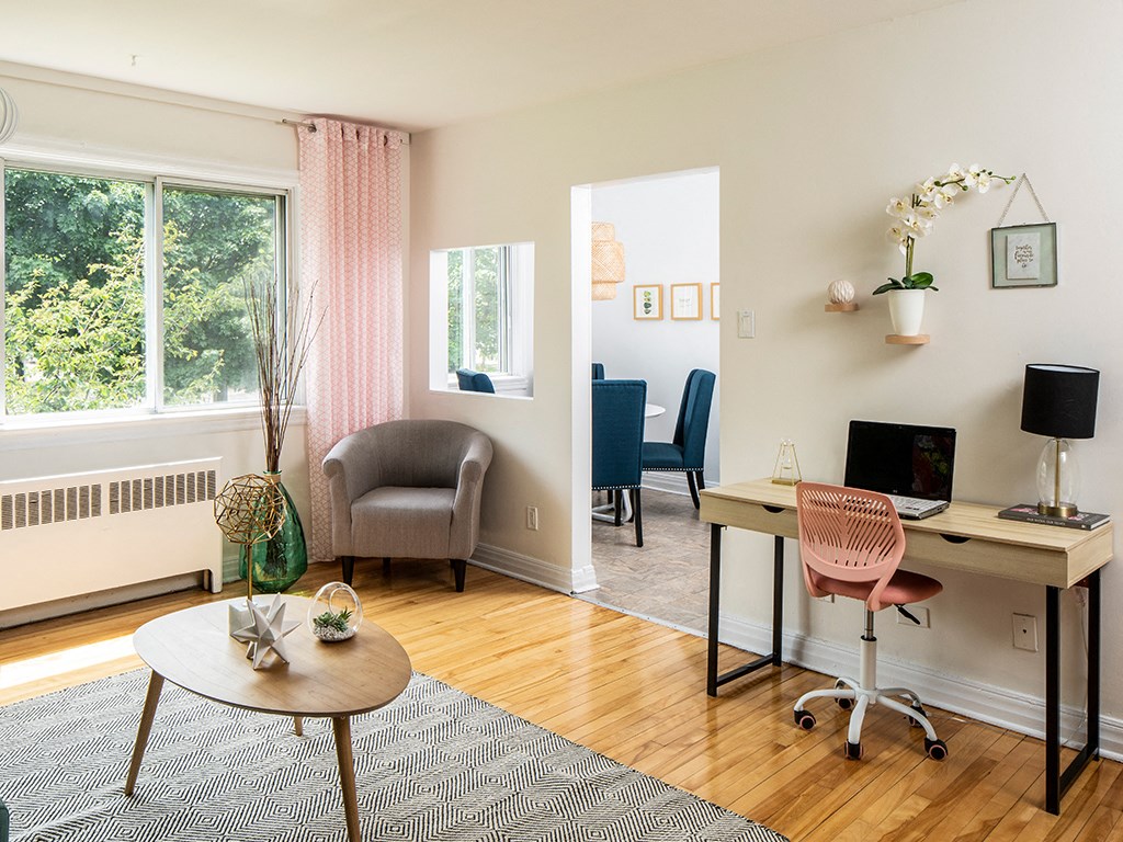 a living room with a desk and a window
