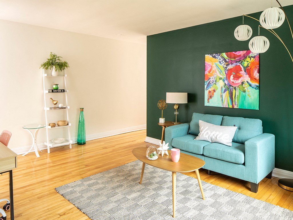 a living room with a green wall and a blue couch