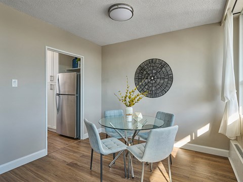 A dining room with a glass table and chairs.