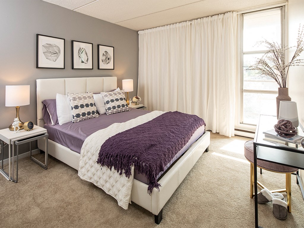 a bedroom with a bed and a purple blanket
