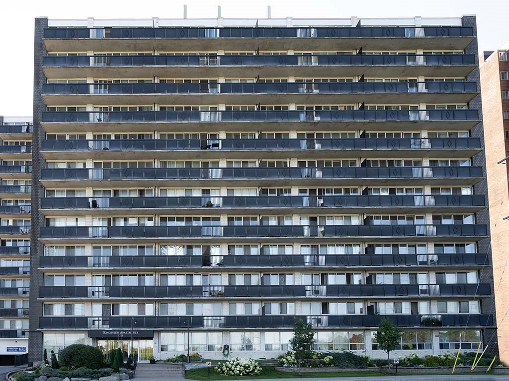 a tall building with many windows and a street in front of it