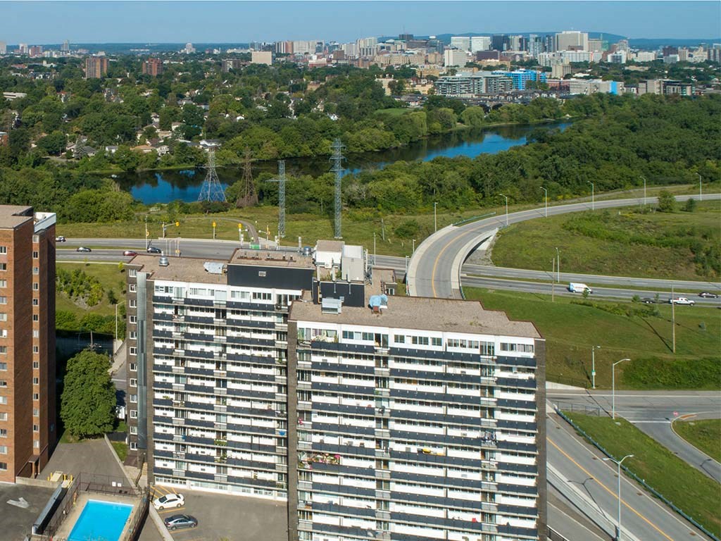 an aerial view of an apartment building with a highway in the background