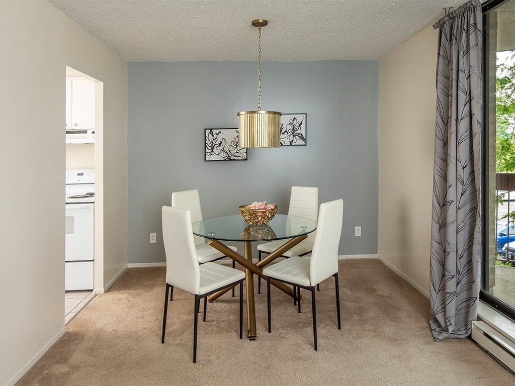 a dining room with a glass table and white chairs