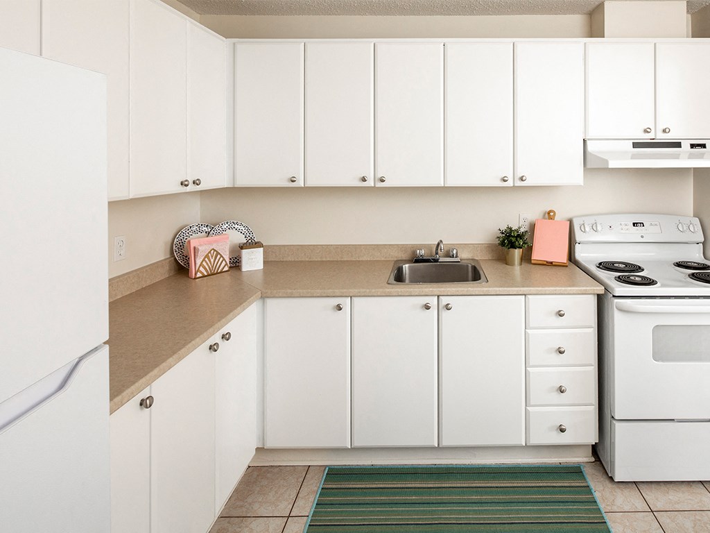 a kitchen with white appliances and white cabinets