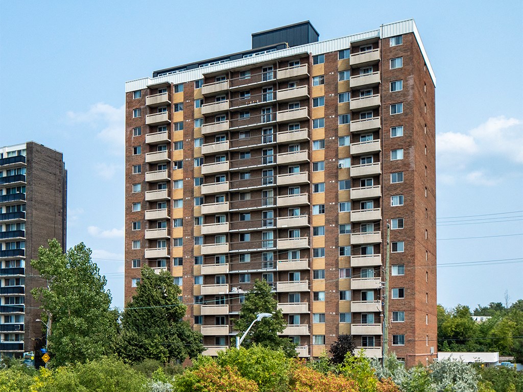 a tall apartment building with trees in front of it