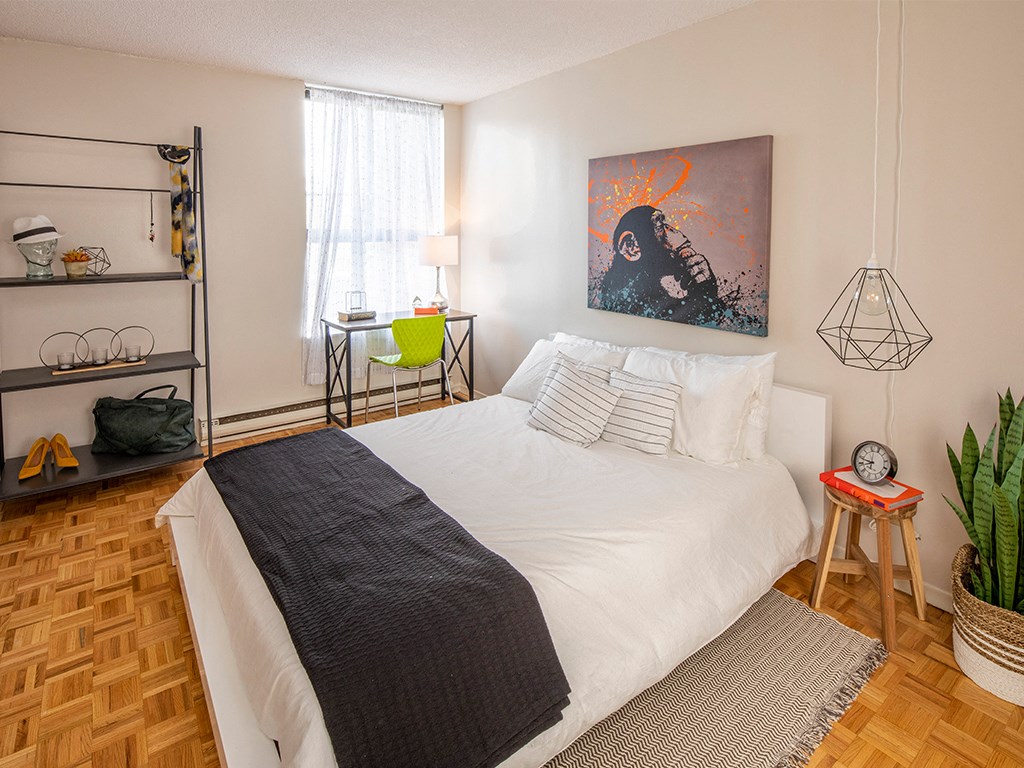 a bedroom with a white bed and a painting on the wall