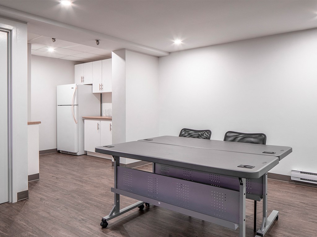 a room with a ping pong table and a refrigerator