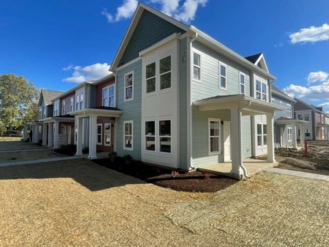 A row of houses with a blue sky in the background.