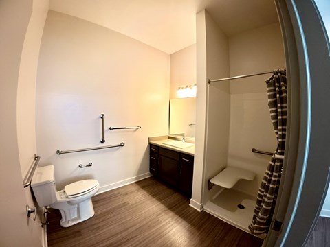 A bathroom with a toilet, sink, and shower.