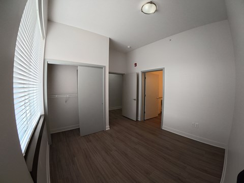 A room with a white wall and a brown floor.