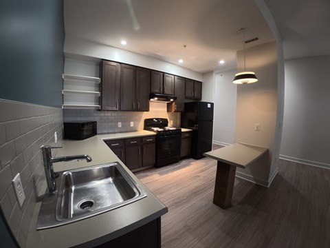 A kitchen with a sink and a refrigerator.