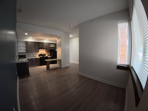A modern kitchen with dark wood floors and white walls.