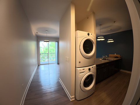 A laundry room with a washer and dryer stacked on top of each other.