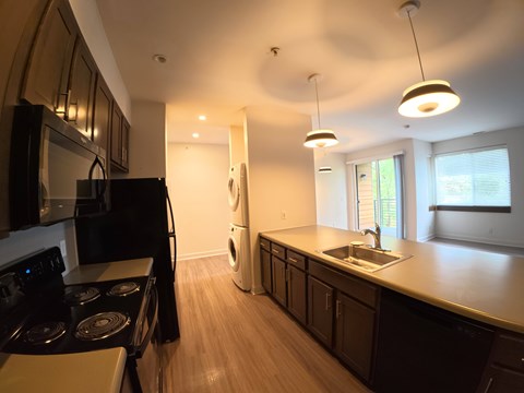A modern kitchen with dark wood cabinets and stainless steel appliances.