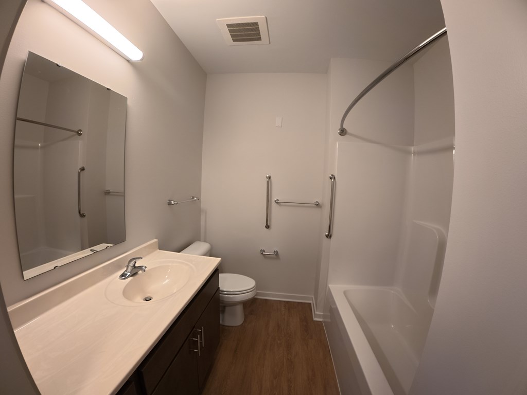 A bathroom with a sink, toilet, and bathtub.