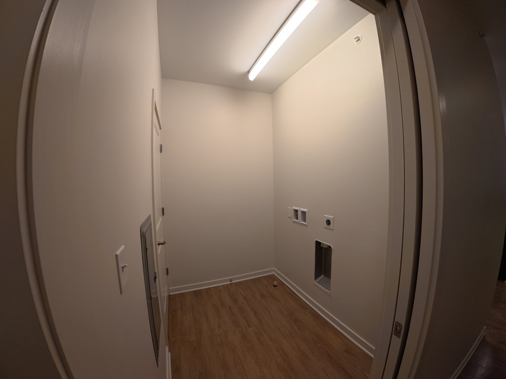 A small, empty room with a door on the left and a window on the right.