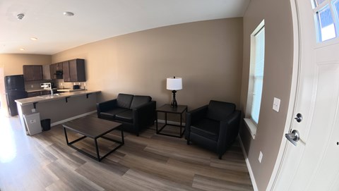 A living room with a black couch and a coffee table.