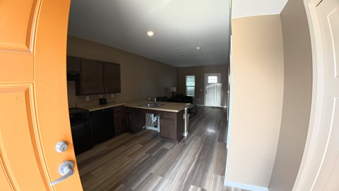 A modern kitchen with wooden floors and a large island.