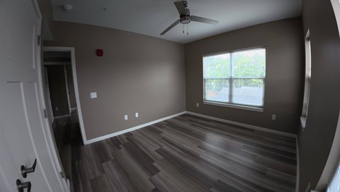 A room with a ceiling fan and a window.