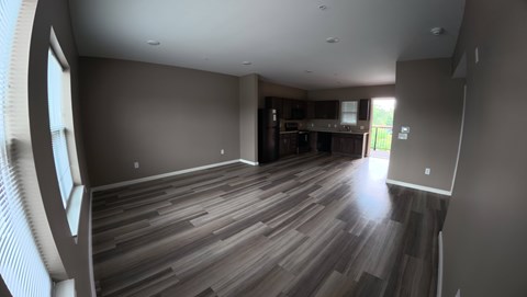 A room with wooden flooring and a large window.