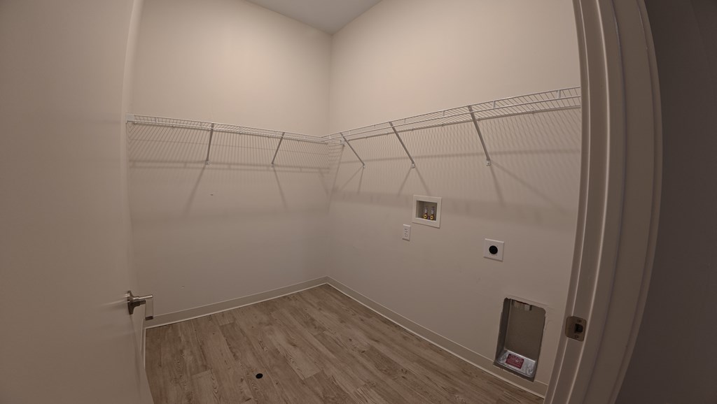 A room with a white wall and a wooden floor.