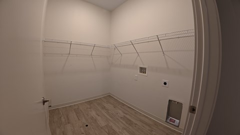 A room with a white wall and a wooden floor.