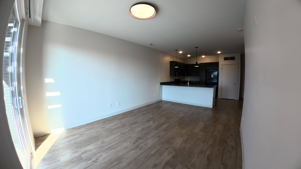 A room with a wooden floor and a white ceiling with a light fixture.