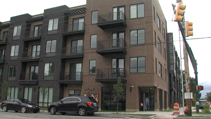 A black car is parked in front of a building.