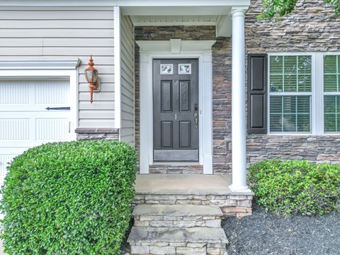 A house with a grey front door and a white garage door.