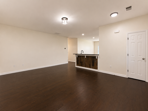 A room with a wooden floor and a white door.