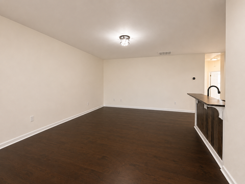 Empty room with wooden floor and white walls.