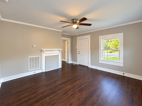A room with a fireplace and a ceiling fan.