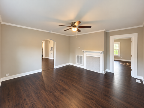 A room with a fireplace and wood flooring.