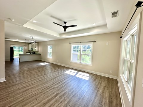 A room with a ceiling fan and wooden flooring.