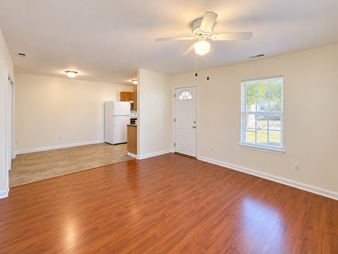 A room with wooden floors and a ceiling fan.