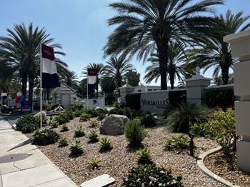 A garden with a Versailles sign in the background.