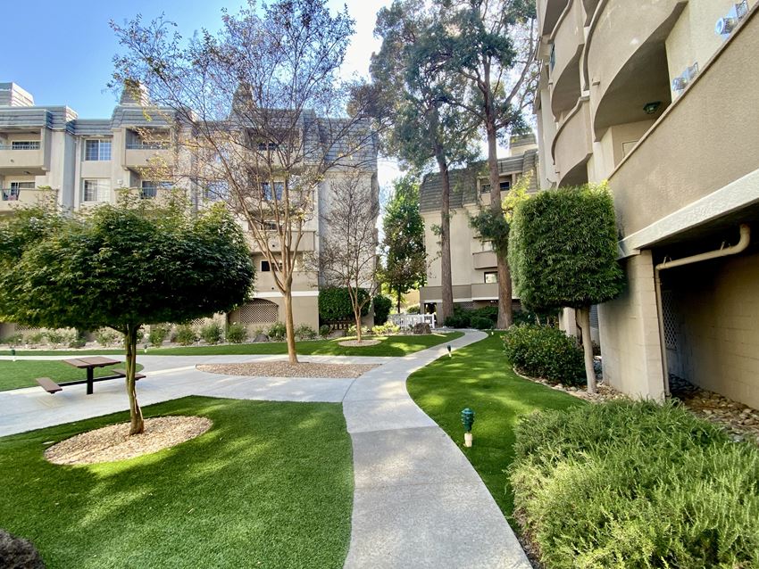 a walkway between two apartment buildings with a picnic table in the middle of the walkway