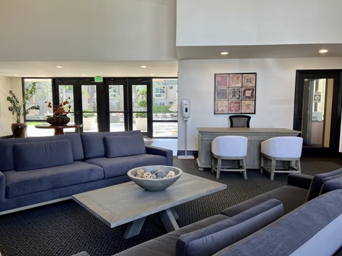 a living room with blue couches and chairs and a table with chairs