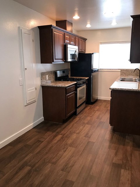 a kitchen with wooden floors and a stove and a refrigerator