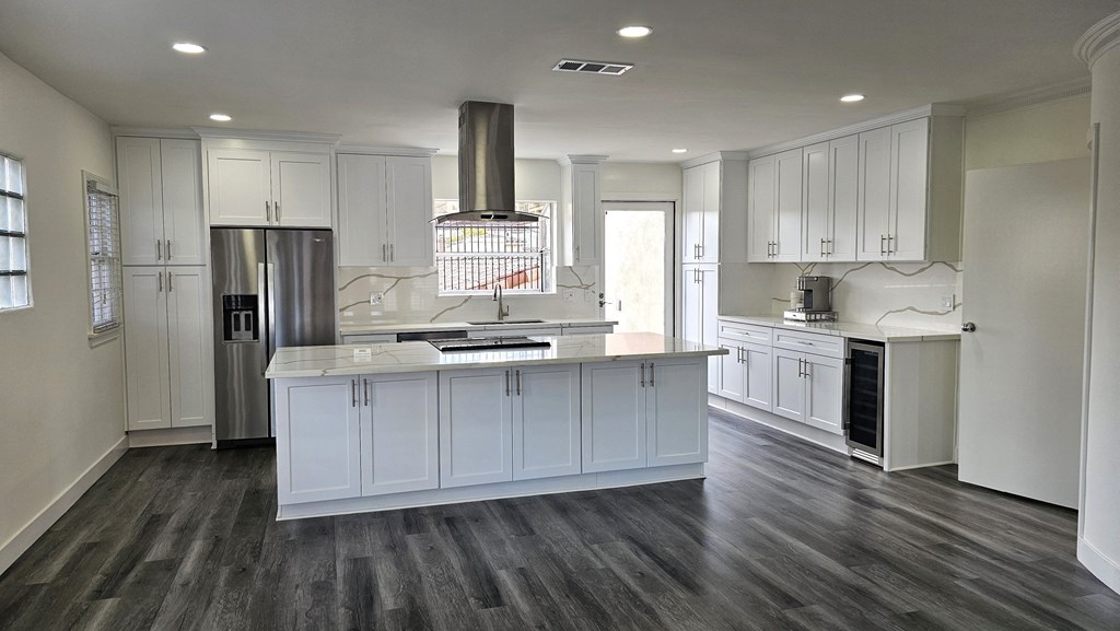a kitchen with white cabinets and a large center island