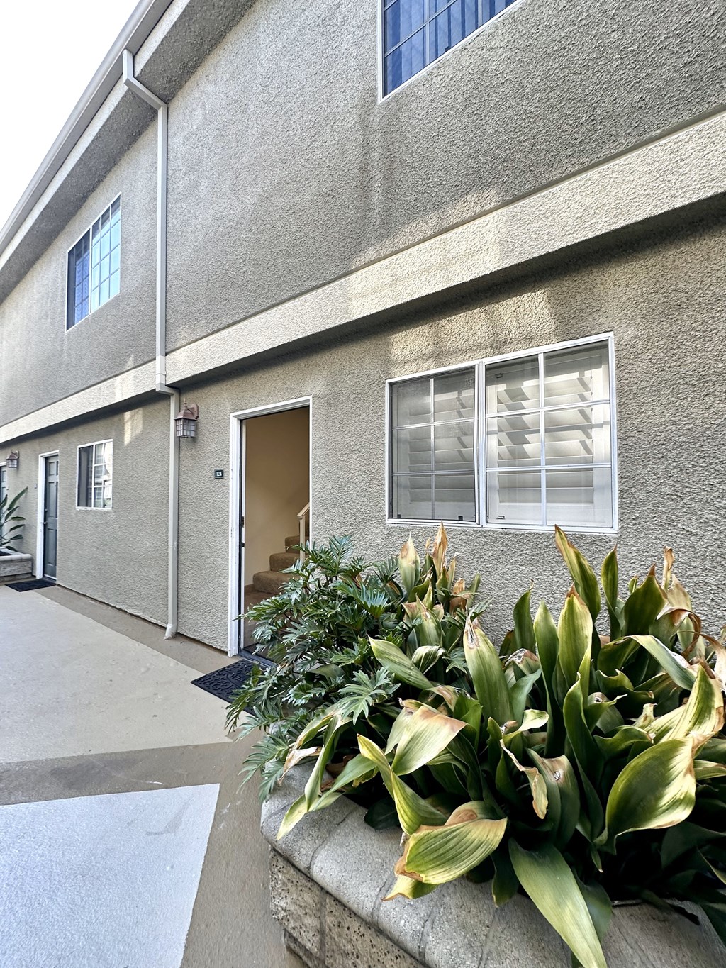 the front of a building with plants in front of it