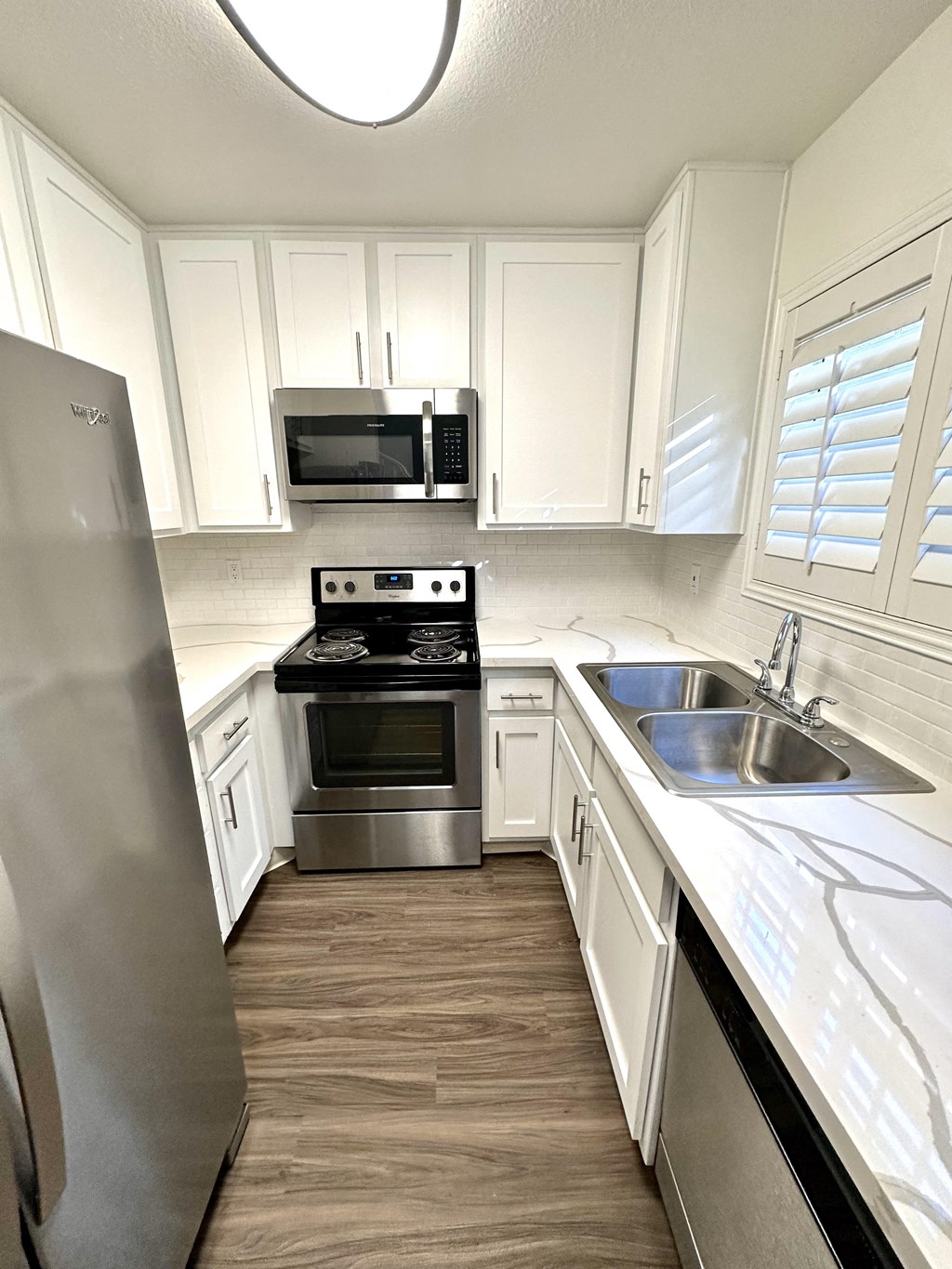 a small kitchen with white cabinets and stainless steel appliances