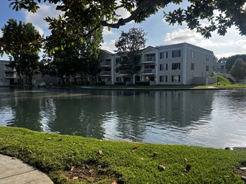 A building is reflected in the water of a lake.
