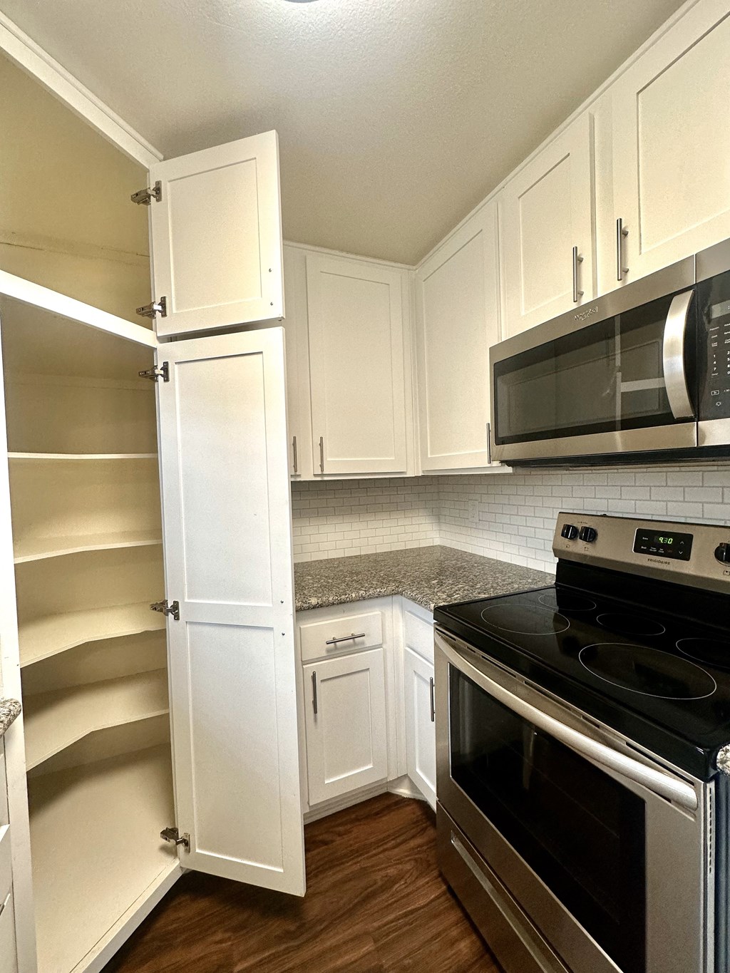 a kitchen with white cabinets and a black stove