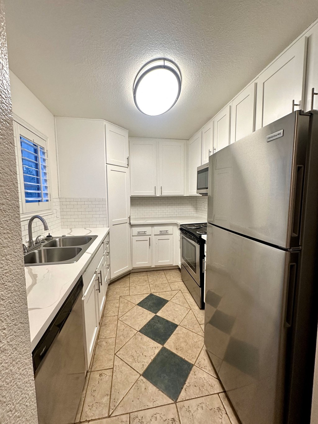 a kitchen with stainless steel appliances and white cabinets