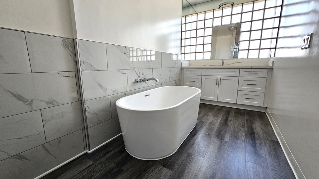 a white bathroom with a soaking tub and a sink
